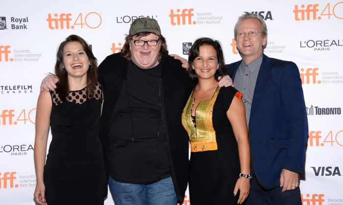 Director Michael Moore, second from left, poses with people in his film, from left Jenny Tumas, Amel Smaoui and Pasi Sahlberg at the "Where to Invade Next" premiere  on day 1 of the Toronto International Film Festival at The Princess of Wales Theatre on Thursday, Sept. 10, 2015, in Toronto. (Photo by Evan Agostini/Invision/AP)